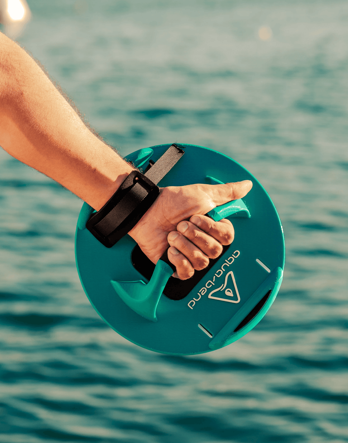 Hand holding an Aqua-Bend FIT disc by its Multi-Grip handle above open water