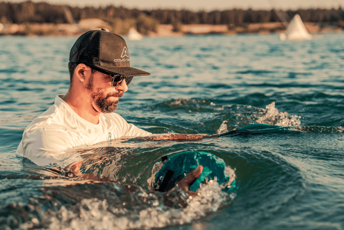 Man in open water holding an Aqua-Bend disc at the surface